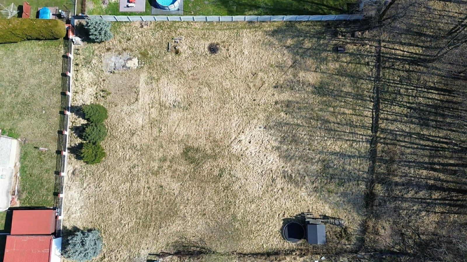 Widok z góry na działkę budowlaną na sprzedaż w centrum Imielina, zaznaczający prostokątny kształt działki i jej ogrodzenie.
