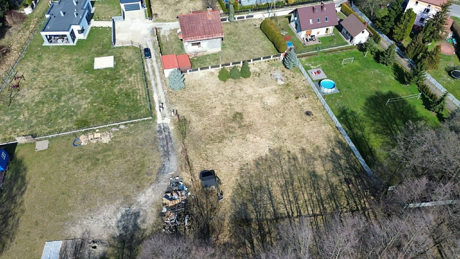 Ujęcie z góry drogi dojazdowej do pustej działki budowlanej na sprzedaż zlokalizowanej w centrum Imielina.