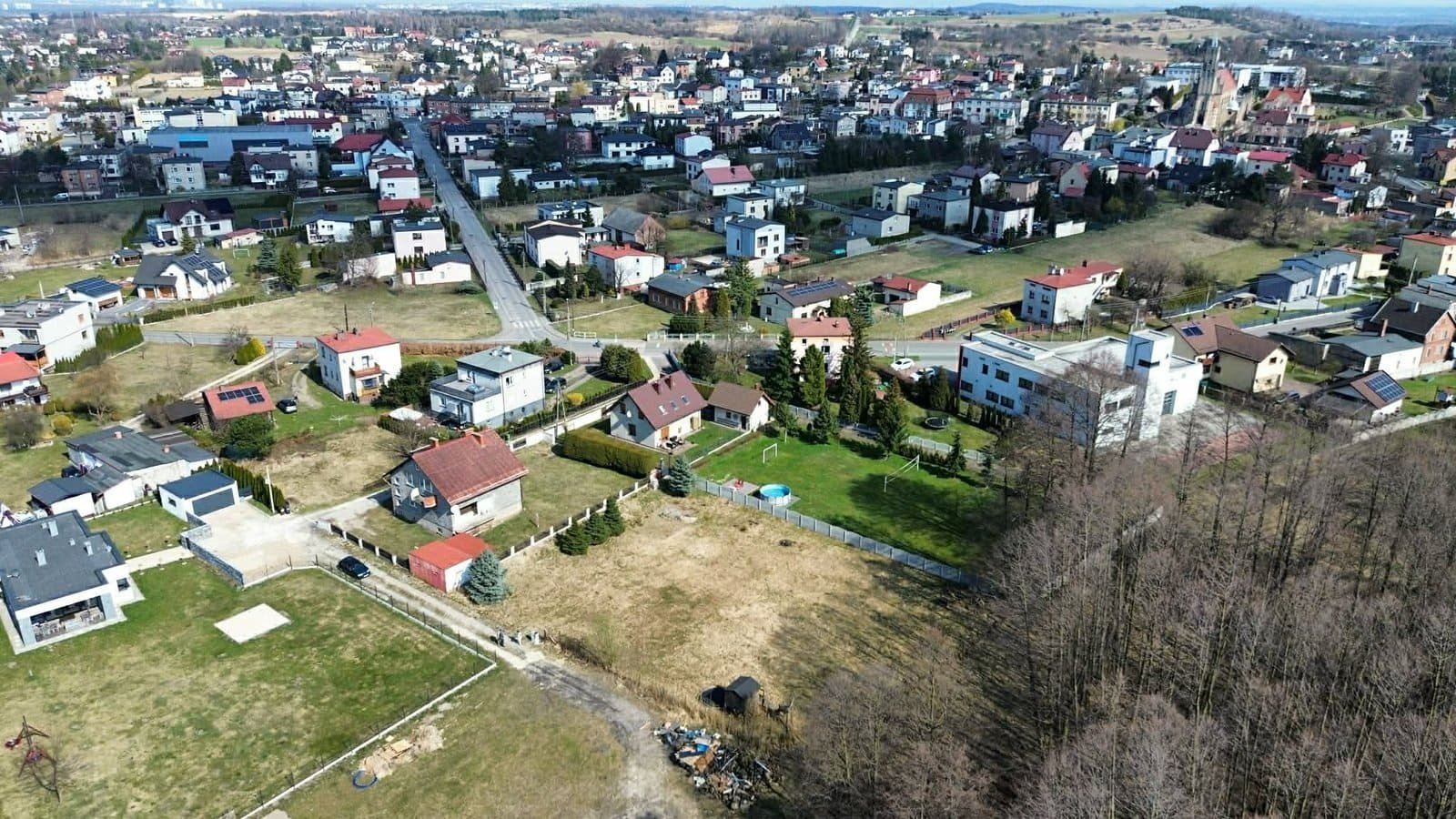 Ujęcie okolicy domów jednorodzinnych w centrum Imielina z widoczną na dole pustą działką budowlaną na sprzedaż.